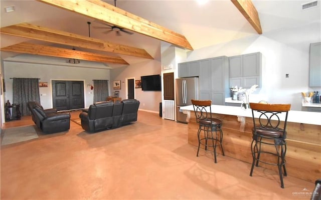 living room featuring vaulted ceiling with beams and ceiling fan