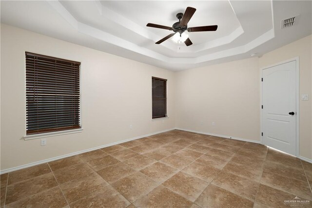 2002 Butkus Dr, Edinburg, TX 78542 - empty room featuring a tray ceiling, ceiling fan, and baseboards