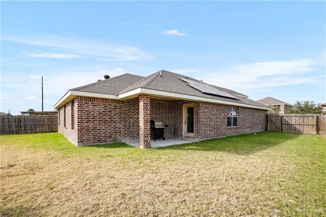 2002 Butkus Dr, Edinburg, TX 78542 - rear view of property featuring roof mounted solar panels, a patio, brick siding, and roof with shingles