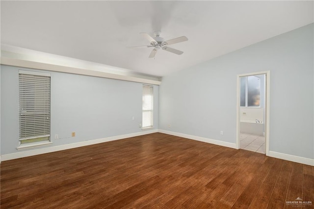 spare room featuring wood-type flooring, vaulted ceiling, and ceiling fan