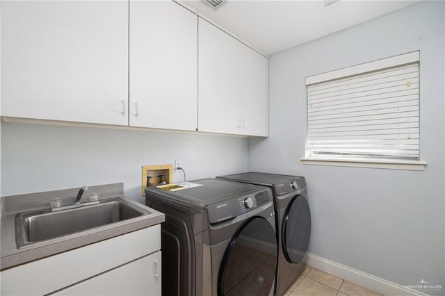 washroom featuring washer and clothes dryer, cabinets, light tile patterned floors, and sink