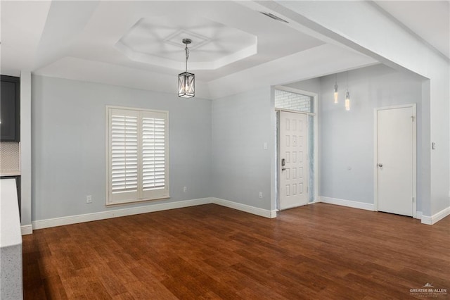 interior space featuring hardwood / wood-style floors, a tray ceiling, and an inviting chandelier