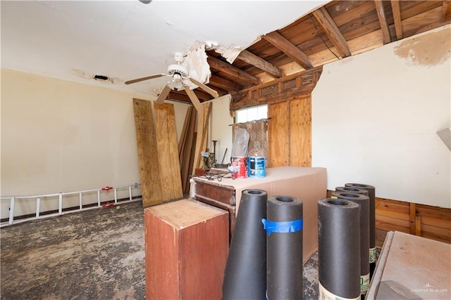 interior space featuring ceiling fan and wood walls