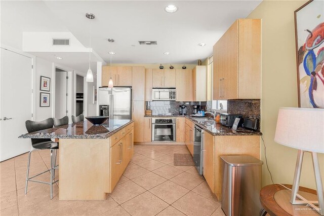 310A Padre Blvd Unit 2304, South Padre Island, TX 78597 - kitchen with appliances with stainless steel finishes, light brown cabinets, tasteful backsplash, a breakfast bar area, and recessed lighting
