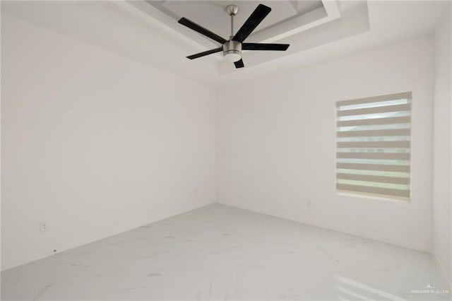 2810 E Uva Ave, Hidalgo, TX 78557 - spare room featuring light marble finish floors, a raised ceiling, a ceiling fan, and baseboards