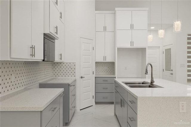 2810 E Uva Ave, Hidalgo, TX 78557 - kitchen featuring a sink, light marble finish flooring, gray cabinetry, and an island with sink