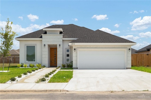 2810 E Uva Ave, Hidalgo, TX 78557 - view of front of house with a shingled roof, driveway, a garage, and stucco siding