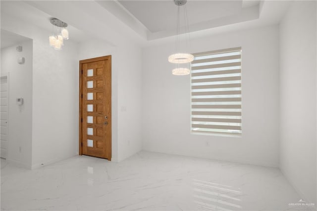 2810 E Uva Ave, Hidalgo, TX 78557 - spare room featuring a chandelier, marble finish flooring, and a tray ceiling