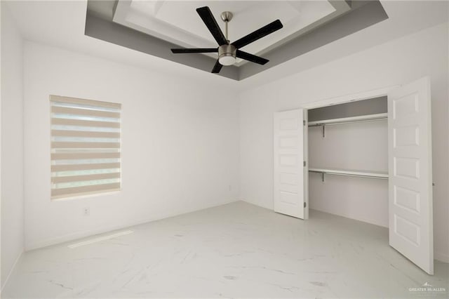 2810 E Uva Ave, Hidalgo, TX 78557 - unfurnished bedroom featuring a raised ceiling, marble look tile flooring, a closet, and baseboards