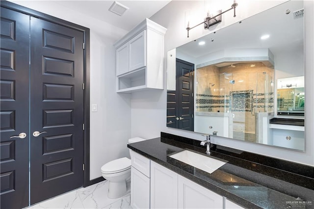 bathroom featuring vanity, toilet, and a shower with shower door