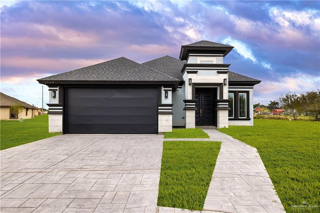 prairie-style home with a lawn and a garage