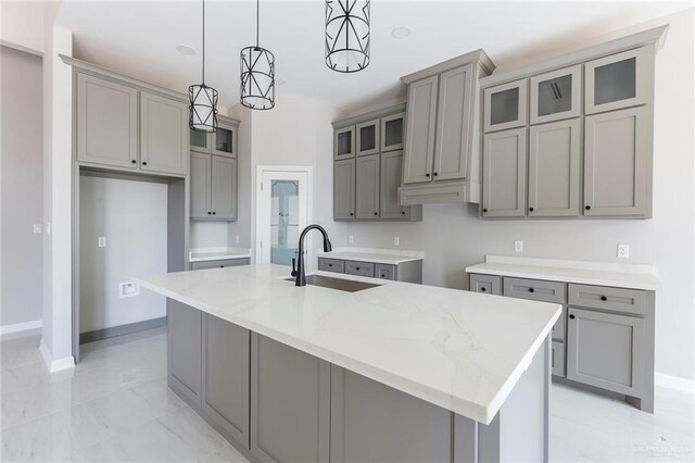 kitchen with sink, decorative light fixtures, a center island with sink, and a notable chandelier