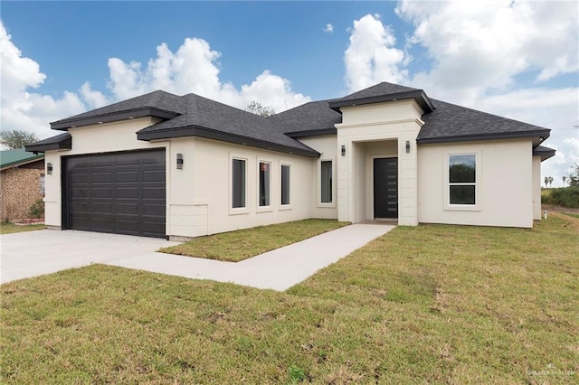 prairie-style house featuring a garage and a front lawn