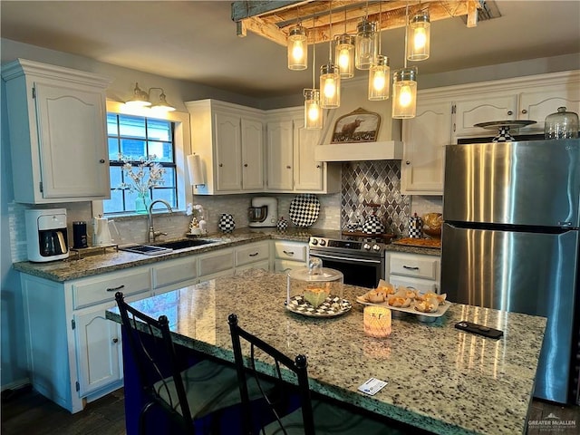 kitchen with white cabinets, a center island, stainless steel appliances, and sink