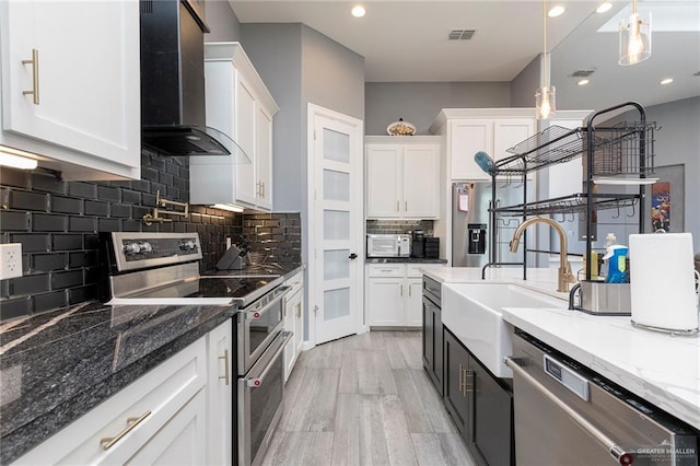 1803 Lago Michigan St, Edinburg, TX 78542 - kitchen with stainless steel appliances, wall chimney exhaust hood, white cabinetry, decorative backsplash, and recessed lighting