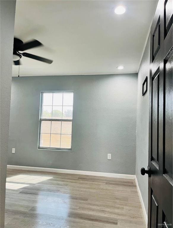 unfurnished room with ceiling fan and light wood-type flooring