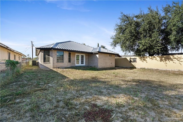 back of house with a yard, central air condition unit, and french doors