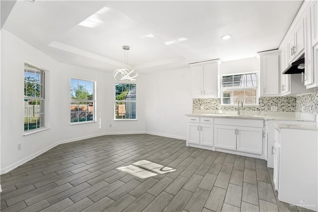 kitchen featuring white cabinetry, sink, dark wood-type flooring, and decorative light fixtures