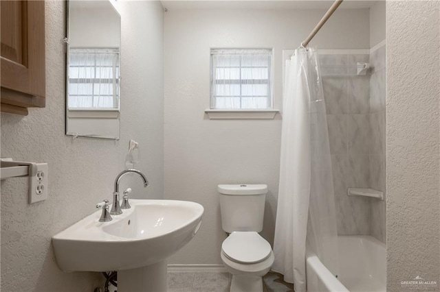 full bathroom featuring sink, shower / bath combo, and toilet