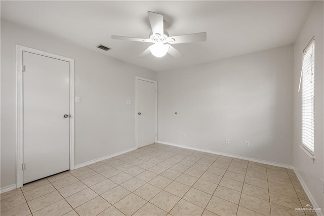 spare room featuring ceiling fan and light tile patterned floors