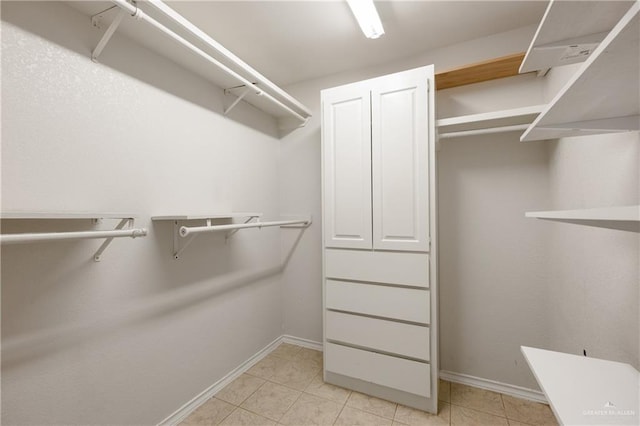 walk in closet with light tile patterned floors