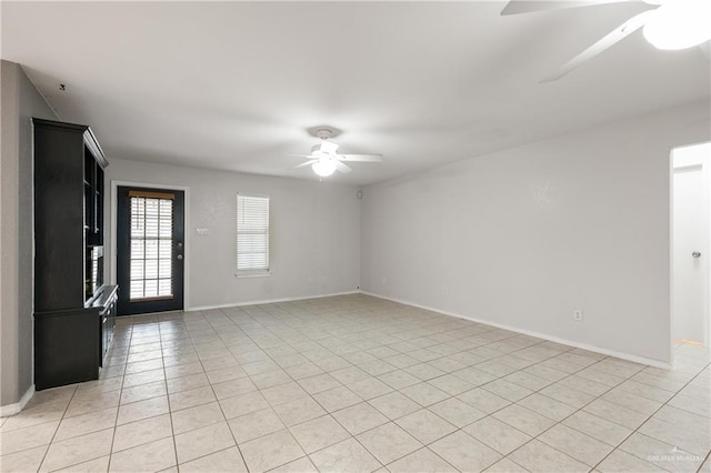 tiled empty room featuring ceiling fan