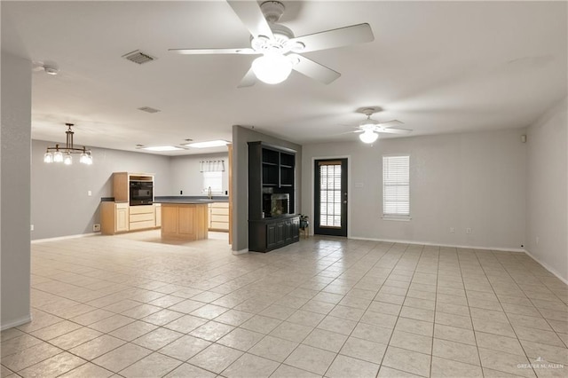 unfurnished living room with light tile patterned floors and ceiling fan with notable chandelier