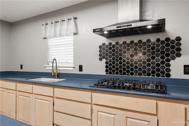 kitchen with sink, wall chimney range hood, light brown cabinetry, and black gas cooktop