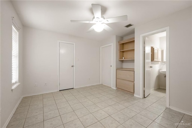 unfurnished bedroom with multiple windows, light tile patterned floors, and ceiling fan