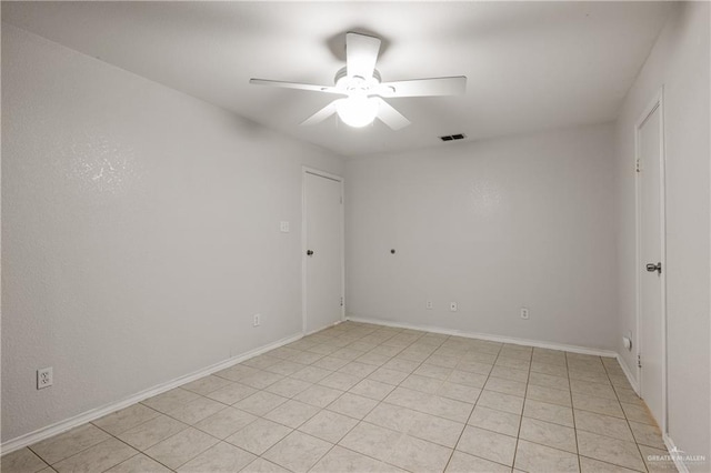 tiled spare room with ceiling fan