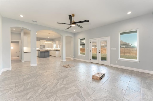 1711 Lago Delton, Edinburg, TX 78542 - unfurnished living room with french doors, ceiling fan, baseboards, arched walkways, and recessed lighting