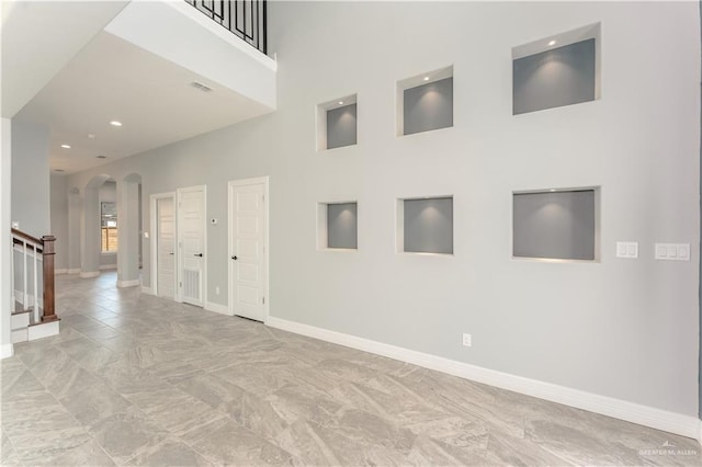 1711 Lago Delton, Edinburg, TX 78542 - unfurnished room featuring arched walkways, baseboards, stairs, recessed lighting, and a towering ceiling