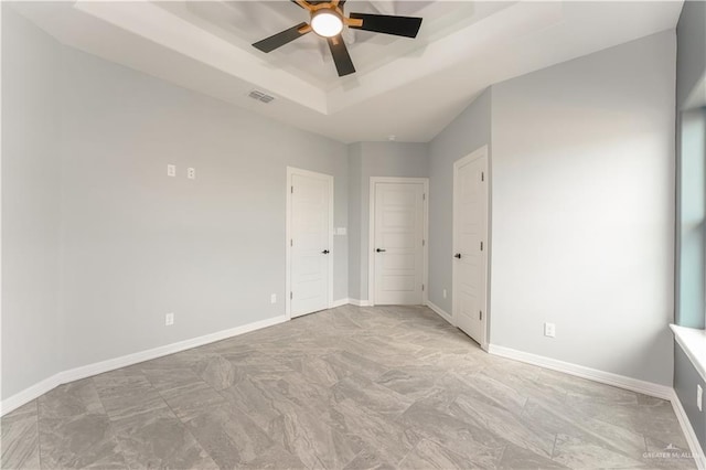 1711 Lago Delton, Edinburg, TX 78542 - unfurnished bedroom featuring a tray ceiling, baseboards, and a ceiling fan