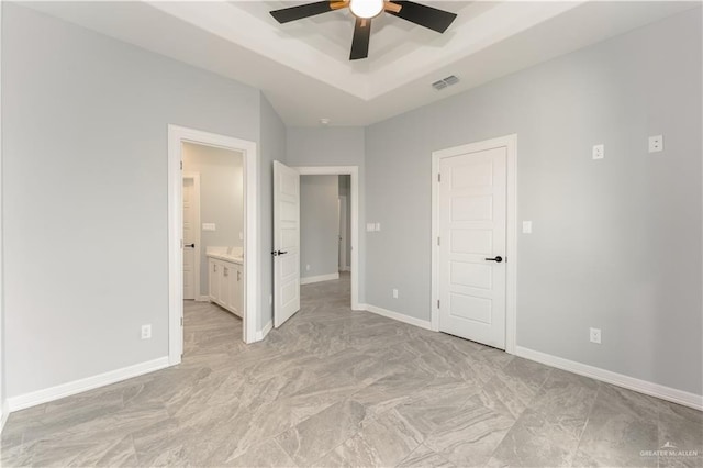 1711 Lago Delton, Edinburg, TX 78542 - unfurnished bedroom with a raised ceiling, baseboards, connected bathroom, and a ceiling fan