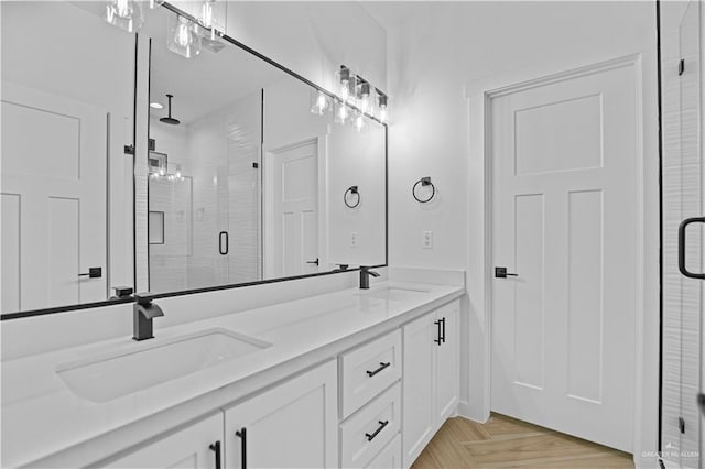 bathroom with parquet flooring, vanity, and a shower with shower door