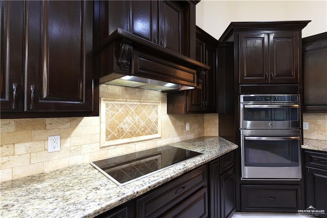 kitchen featuring dark brown cabinets, stainless steel double oven, backsplash, and black electric cooktop