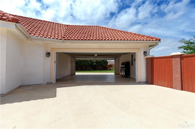 garage featuring driveway and fence