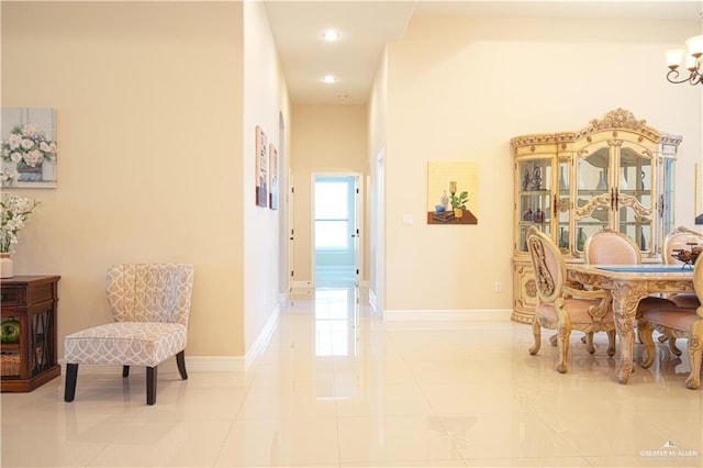 hallway with light tile patterned floors, recessed lighting, an inviting chandelier, and baseboards