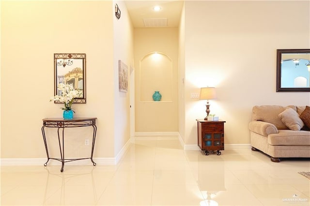 hall featuring tile patterned flooring, visible vents, and baseboards