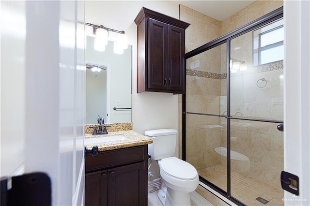 bathroom with toilet, a stall shower, and vanity