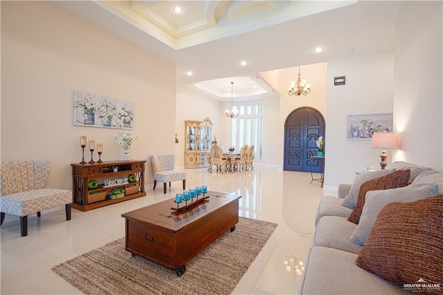 living room featuring light tile patterned flooring, recessed lighting, baseboards, a tray ceiling, and an inviting chandelier