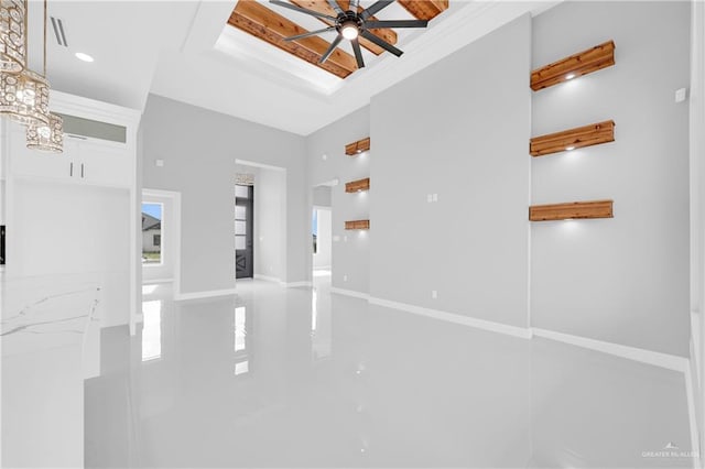 unfurnished living room featuring baseboards and a ceiling fan