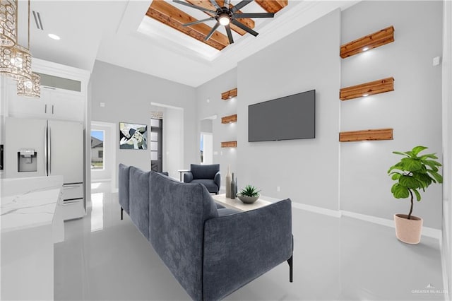 unfurnished living room featuring visible vents, baseboards, a raised ceiling, a sink, and ceiling fan with notable chandelier