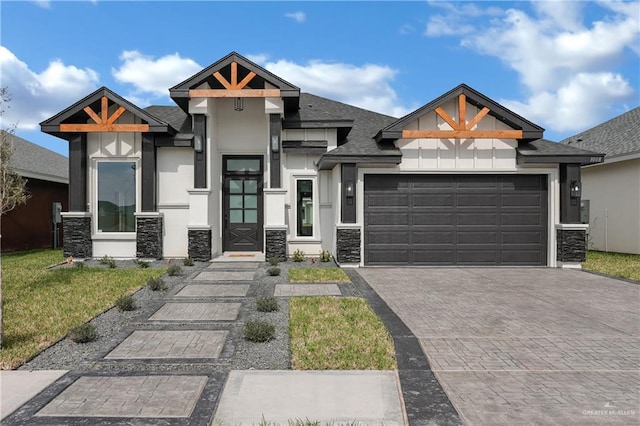 view of front facade with an attached garage, a shingled roof, decorative driveway, stucco siding, and a front yard