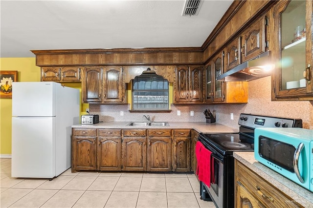 kitchen with sink, light tile patterned floors, and appliances with stainless steel finishes