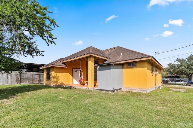 rear view of property featuring a yard