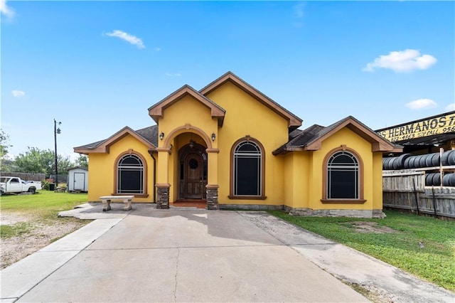 view of front of property with a storage shed and a front lawn