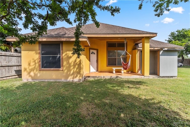 rear view of property with a yard