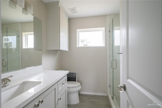 bathroom with vanity, hardwood / wood-style flooring, toilet, and a shower with door