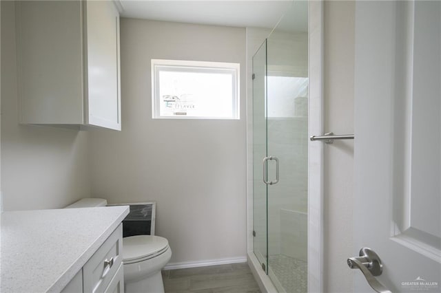 bathroom with hardwood / wood-style floors, vanity, toilet, and an enclosed shower